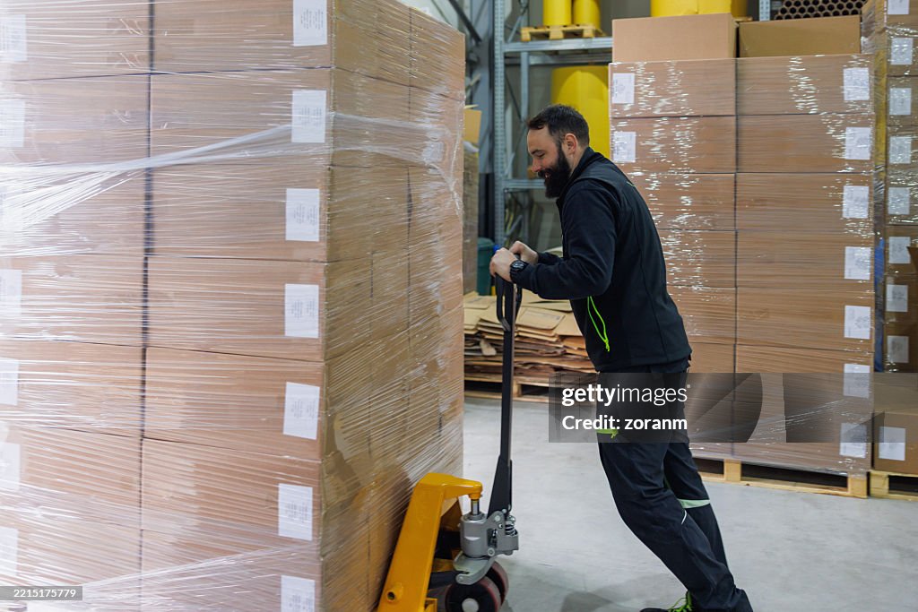 Man Loading Stack Of Goods On Pallet Jack In The Warehouse High-Res ...