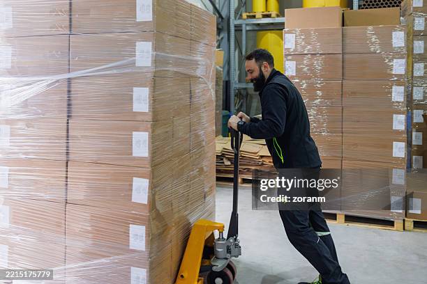 Man Loading Stack Of Goods On Pallet Jack In The Warehouse High-Res ...