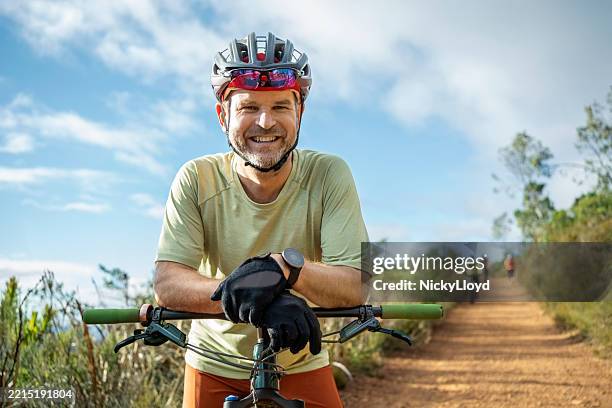 mountain biker resting with helmet and gloves on trail - cyclist stock pictures, royalty-free photos & images
