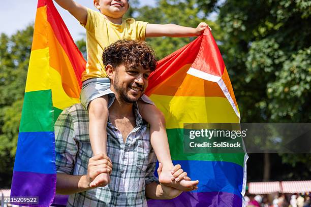 joyful father and son at pride event - gay pride parade stock pictures, royalty-free photos & images