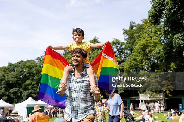 father and son enjoying pride festivities - gay pride parade stock pictures, royalty-free photos & images