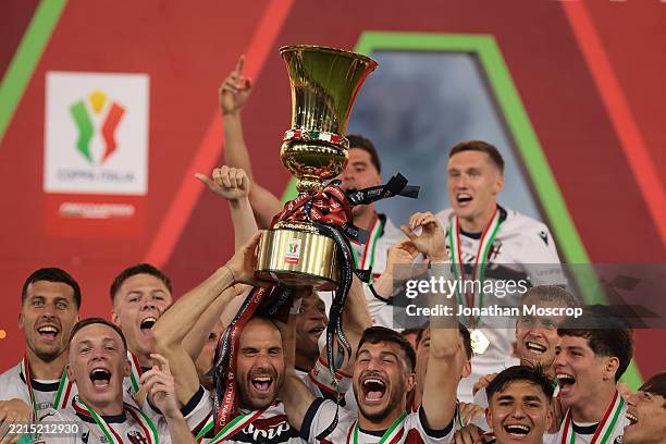 Bologna FC players celebrate with the trophy on the podium following the final whistle of the Coppa Italia Final match between AC Milan and Bologna...