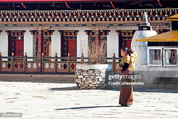 devotee with child on back, gangteng monastery, wangdue phodrang district. phobjikha, gangtey valley, bhutan - bhutan stock pictures, royalty-free photos & images