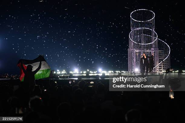 Protestors wave the Palestinian flag as Yuval Raphael representing Israel performs during the rehearsal ahead of Semi Final Round 2 of the 69th...