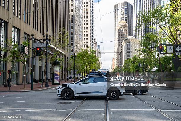Waymo autonomous electric SUV on Market Street amid downtown office towers, San Francisco, California, May 13, 2025.