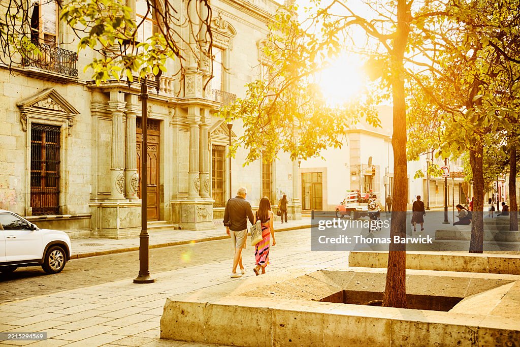 Extreme wide shot senior couple walking on historical street in Oaxaca