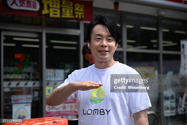 Tomoharu Uchiyama, chief executive officer of Lomby Inc., speaks during a demonstration of autonomous delivery robots outside a 7-eleven store in...