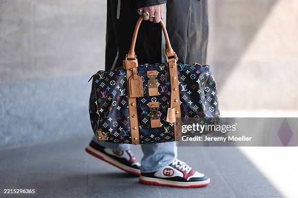 Riccardo Simonetti is seen wearing a calf-length black leather coat with white decorative lines from Moschino; straight-leg light blue jeans from...