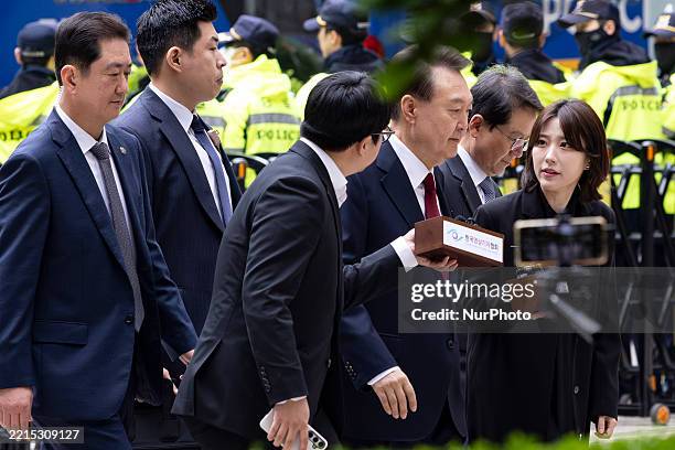 Former President Yoon Suk-yeol, center, who is on trial for leading an insurrection, arrives at the Seoul Central District Court for his fourth...