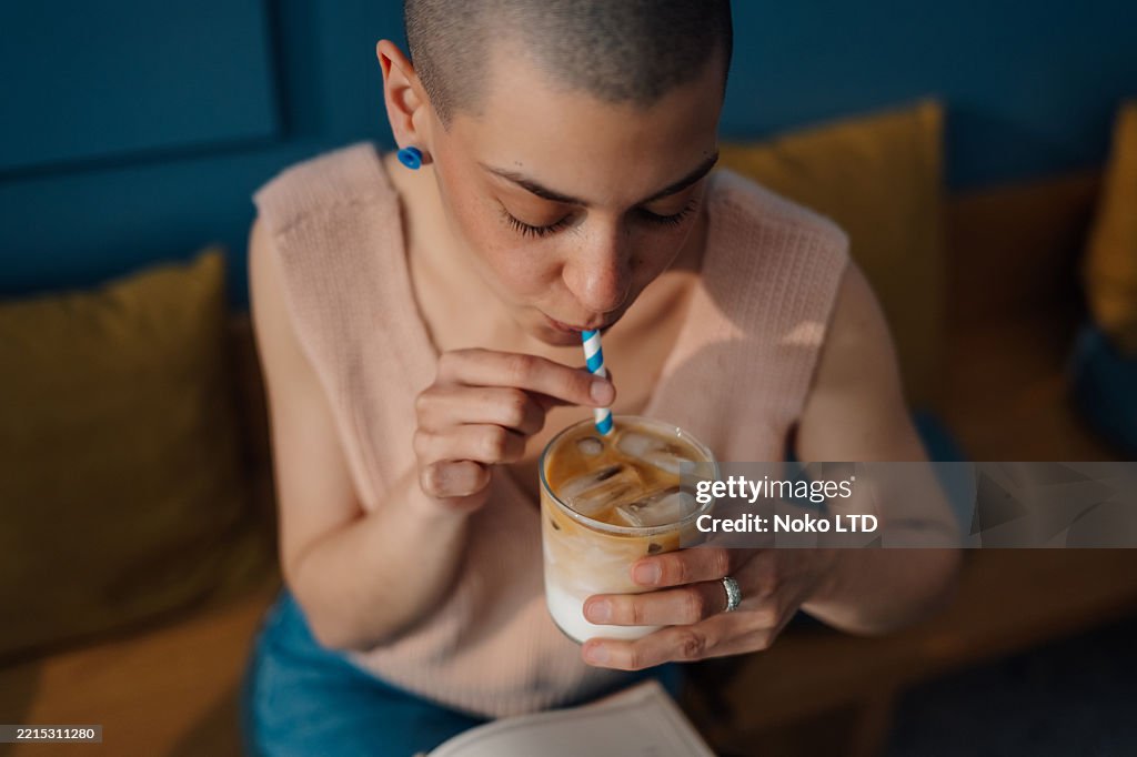 Mujer joven disfrutando de café helado en una cafetería