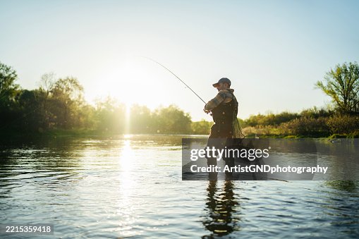 Peaceful fly fishing scene with mid-aged man at sunset. Peaceful fly fishing scene with mid-aged man at sunset.
