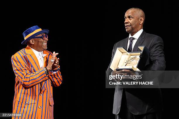 Actor Denzel Washington receives the Honorary Palme d'Or from US director and executive producer Spike Lee ahead of the screening of the film...
