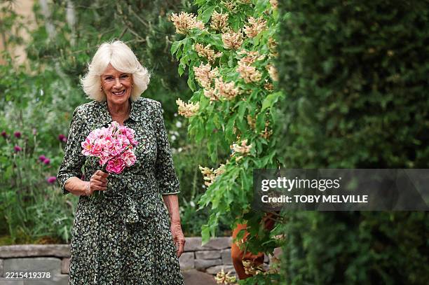 Britain's Queen Camilla holds a bouquet of "The King's Rose" of David Austin Roses, as she attends the preview day at the RHS Chelsea Flower show, in...