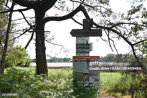 This photograph shows a information poster alerting to the presence of rotting green algae at the entrance to a coastal path along the Etel Ria, in...
