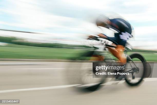 defocused and speedy cycling sports background, single cyclist riding fast - ciclista fotografías e imágenes de stock