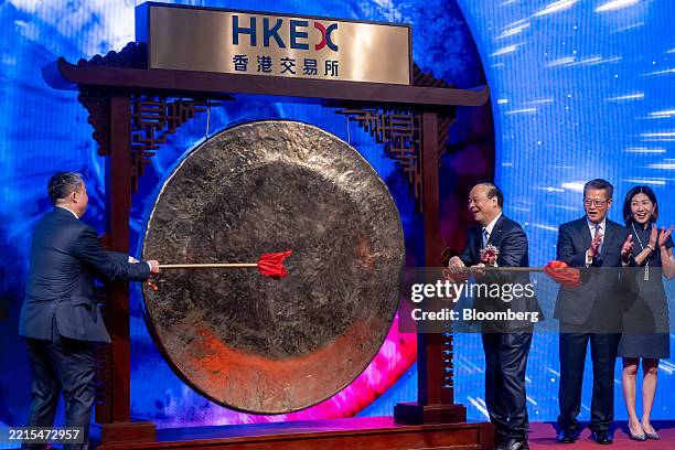 Robin Zeng, founder and chairman of Contemporary Amperex Technology Co. Ltd. , third right, strikes a gong as Paul Chan, Hong Kong's financial...