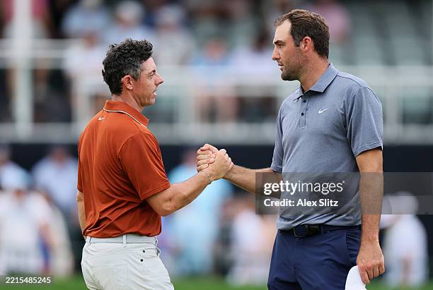 Rory McIlroy of Northern Ireland, left, shakes hands with Scottie Scheffler of the United States on the 18th hole green after finishing the second...