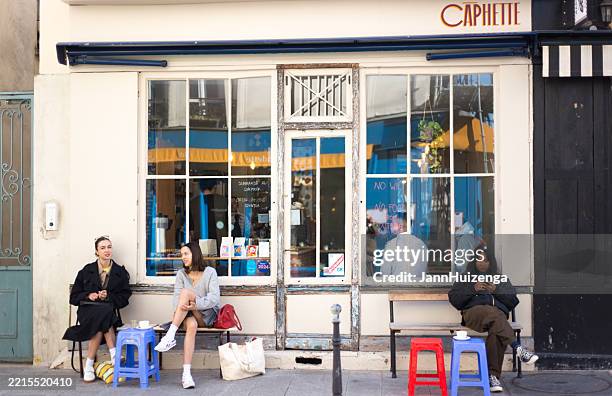 paris, france: young women outside caphette, oberkampf 11th - paris restaurant stock pictures, royalty-free photos & images