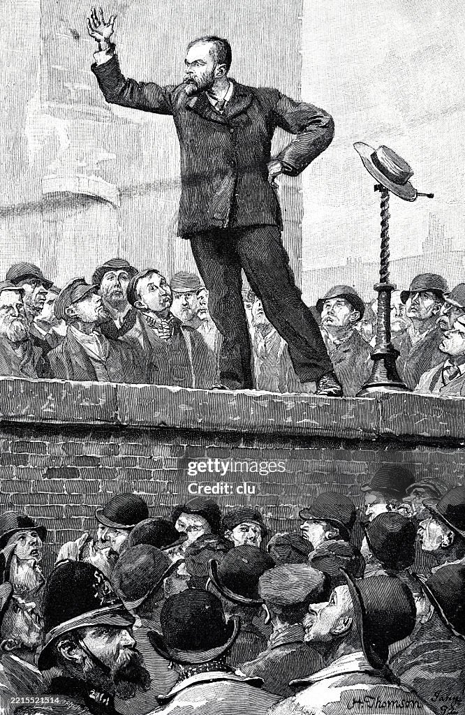 A socialist popular leader, standing on a wall, gives a combative speech to his successors, right arm raised