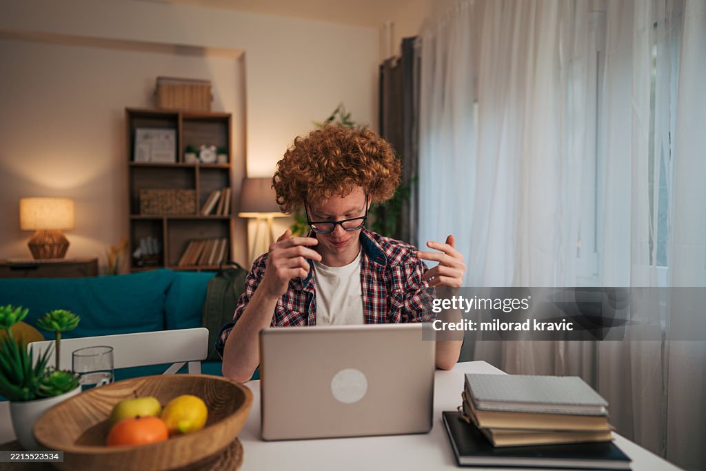 Focused young man working on laptop at home office