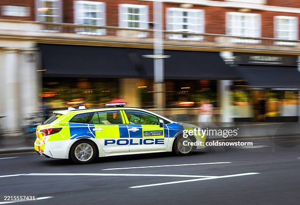 burred motion of metropolitan police car speeding on road in central london, uk - police car stock pictures, royalty-free photos & images