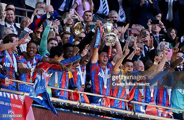 Marc Guehi and Joel Ward of Crystal Palace lift the FA Cup trophy after their team's victory in the Emirates FA Cup Final match between Crystal...