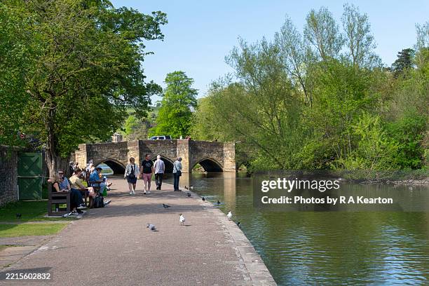 tourists beside the river wye in bakewell - rivière wye derbyshire photos et images de collection