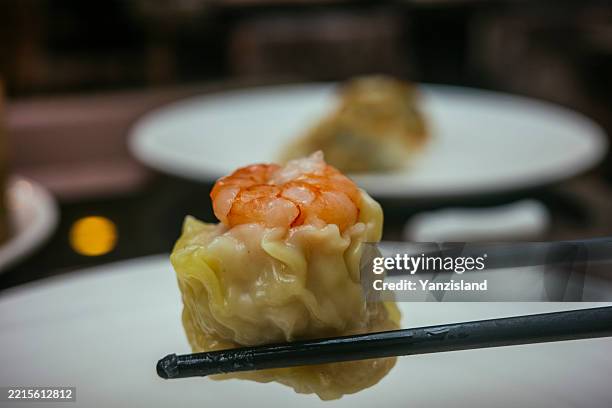 close up of prawn dim sum with chopsticks - chinesische küche stock-fotos und bilder