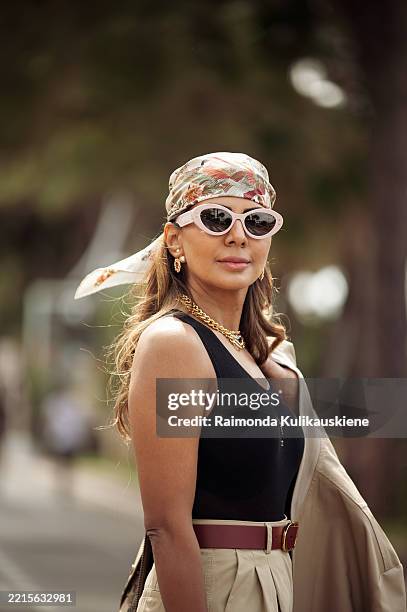 Zufi Alexander wears wide beige pants, black tank top, multicoloured bandana, sunglasses, beige jacket with embroidery, in full look from Dior during...