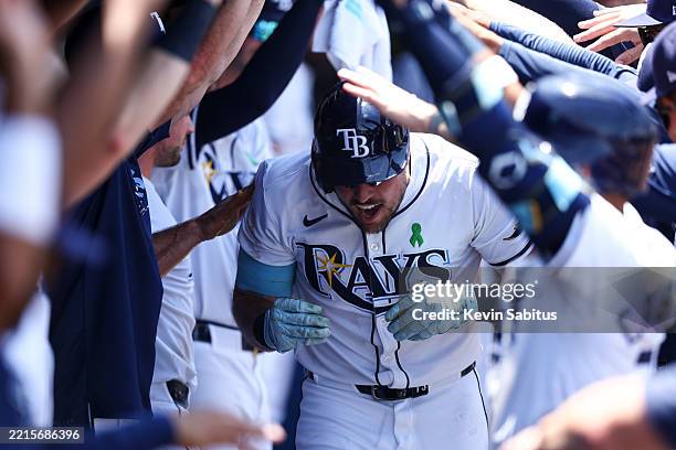 Josh Lowe of the Tampa Bay Rays celebrates with teammates in the dugout after hitting a home run during the fifth inning of a game against the...