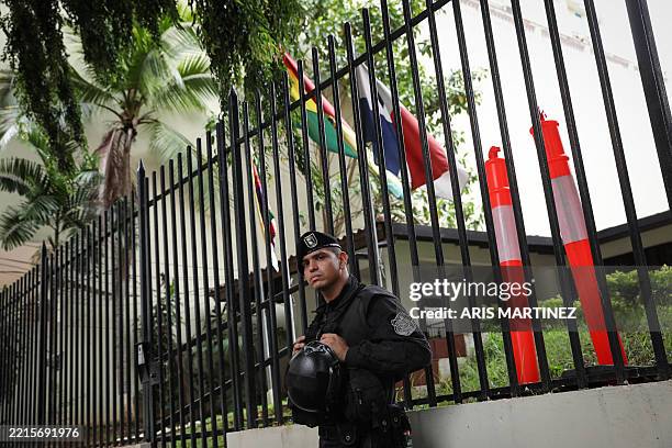 Police officer stands guard outside the Bolivian embassy in Panama City on May 21, 2025. Top union leader Saul Mendez, involved in protests against...