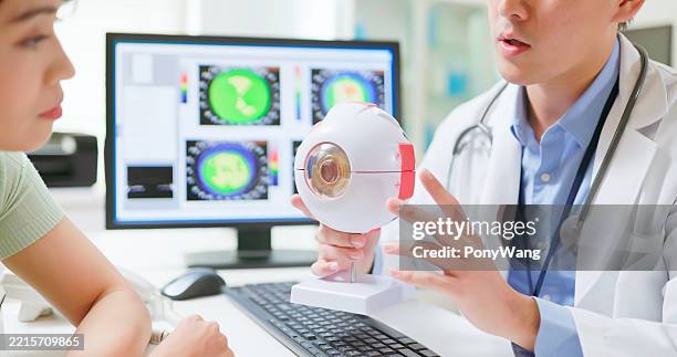 doctor explain by eye model - astigmatismo imagens e fotografias de stock