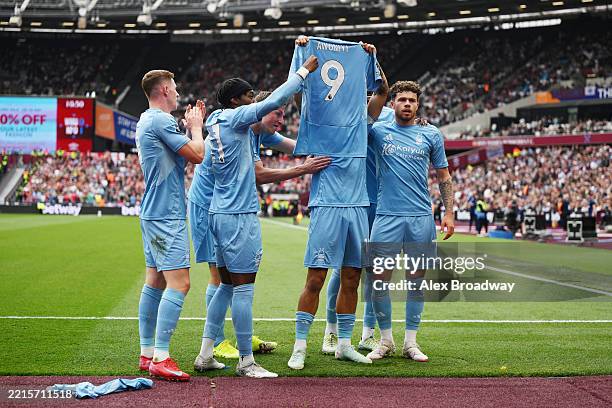 Morgan Gibbs-White of Nottingham Forest holds up a match shirt in support of team mate Taiwo Awoniyi with team mates Elliot Anderson, Anthony Elanga,...