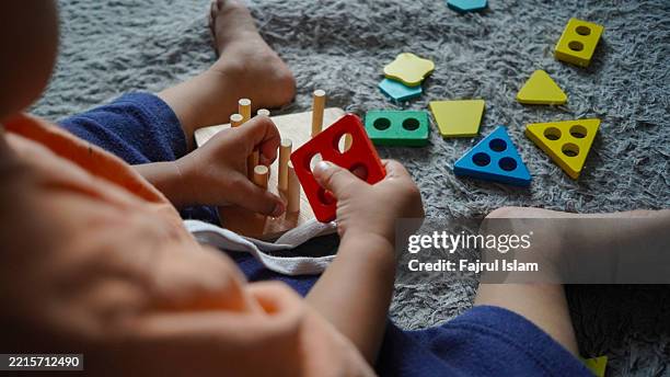 toddler playing with educational toys - achatar la curva de epidemia fotografías e imágenes de stock