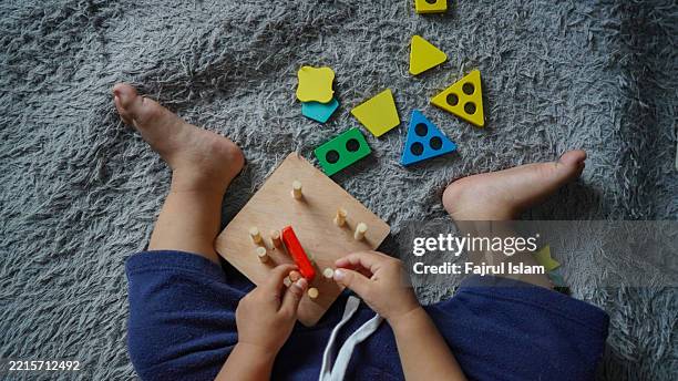 toddler playing with educational toys - achatar la curva de epidemia fotografías e imágenes de stock