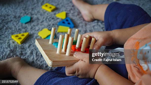 toddler playing with educational toys - achatar la curva de epidemia fotografías e imágenes de stock