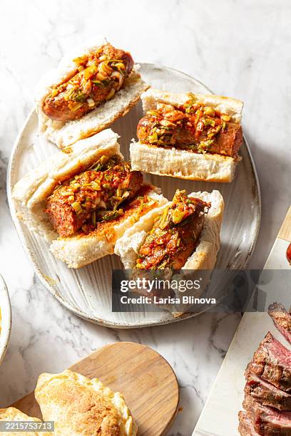 latin american choripan - grilled sausage with bread and spicy sauce - chimichurri stock pictures, royalty-free photos & images