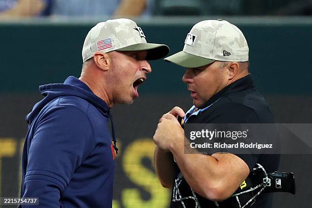 Joe Espada of the Houston Astros argues a call with home plate umpire Nick Mahrley in the third inning of a baseball game against the Texas Rangers...