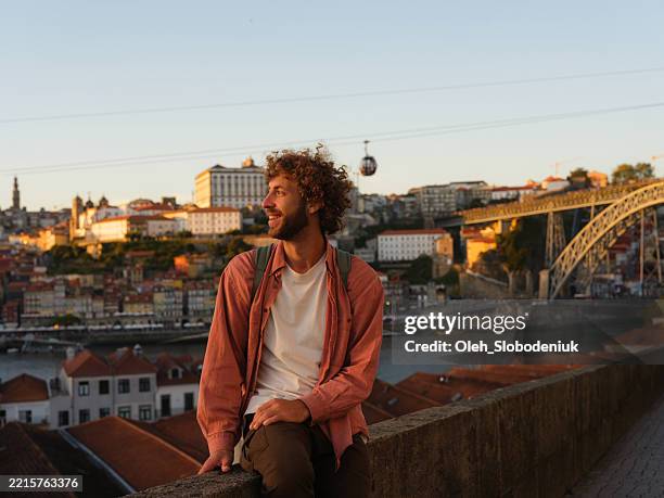 man looking at porto cityscape at sunset during trip to portual - porto portugal stock pictures, royalty-free photos & images