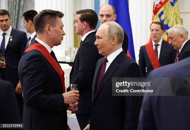 Russian President Vladimir Putin listens to Cosmonaut Oleg Kononenko during an awards ceremony at the Saint Yekeaterina's Hall of the Kremlin, May...