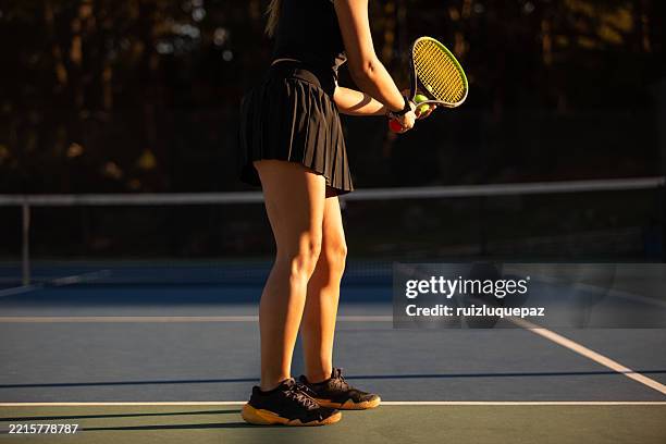 latin american woman serving during a tennis match - sports clothing stock pictures, royalty-free photos & images