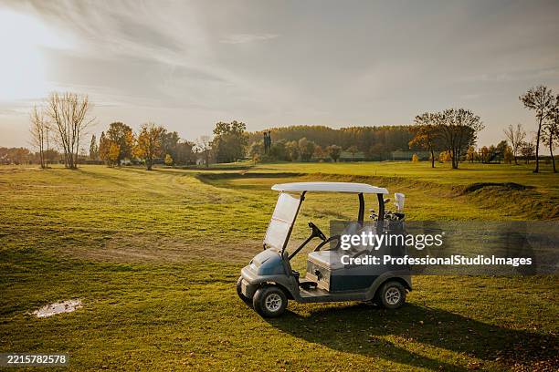golf cart parked on a scenic autumn golf course - golf cart stock pictures, royalty-free photos & images