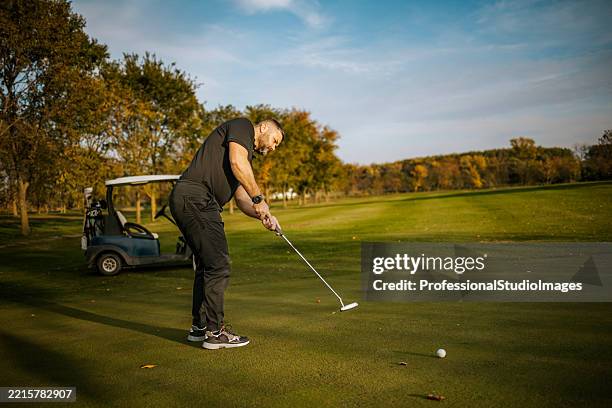 golfer preparing to putt on a sunny autumn day - odyssey putter stock pictures, royalty-free photos & images
