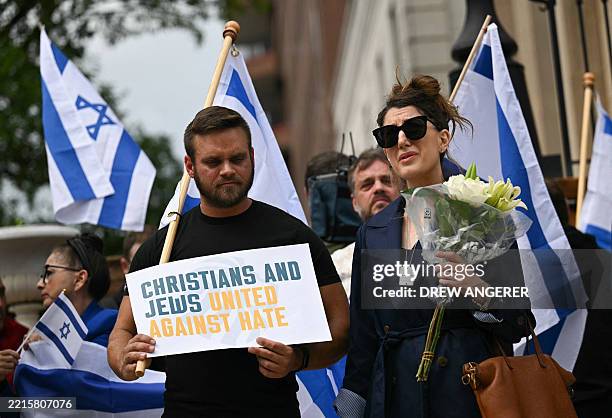 People hold signs and Israeli national flags in a sign of support outside the Capital Jewish Museum following a shooting that left two people dead,...