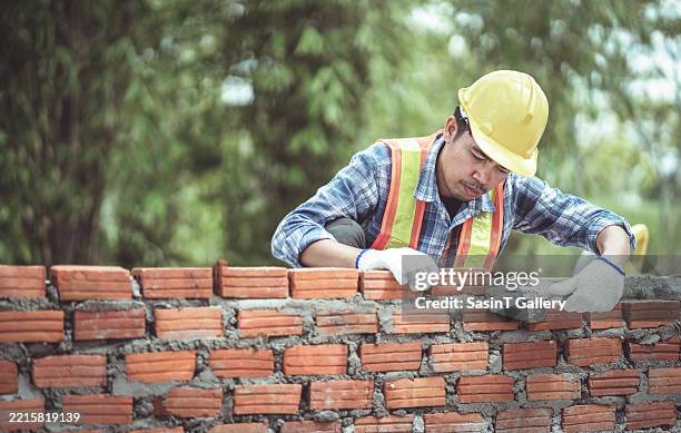 construction worker building brick wall with trowel - albañil fotografías e imágenes de stock
