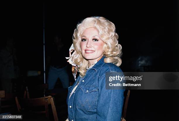 American singer-songwriter Dolly Parton wearing a denim jacket, 1979.