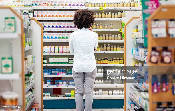 vista trasera de la persona en la farmacia concentrándose en los estantes de los medicamentos - vitamina fotografías e imágenes de stock
