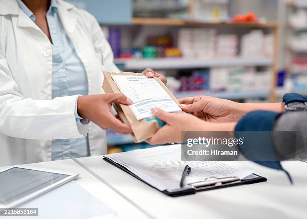 pharmacist handing prescription medication in a dispensary setting - apotheker stockfoto's en -beelden