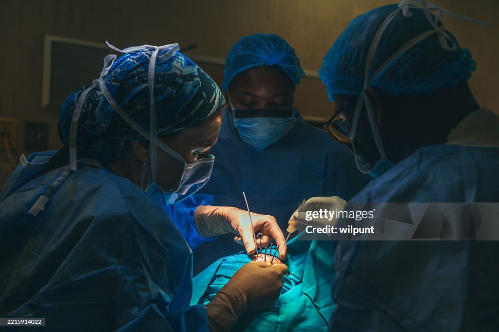 Surgeons performing eye brachytherapy on a young patient in a hospital