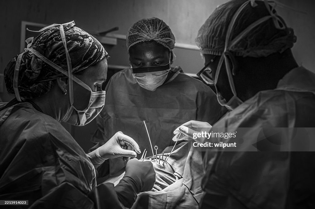 Equipo quirúrgico realizando un delicado procedimiento de braquiterapia ocular en una imagen en blanco y negro de un hospital oncológico